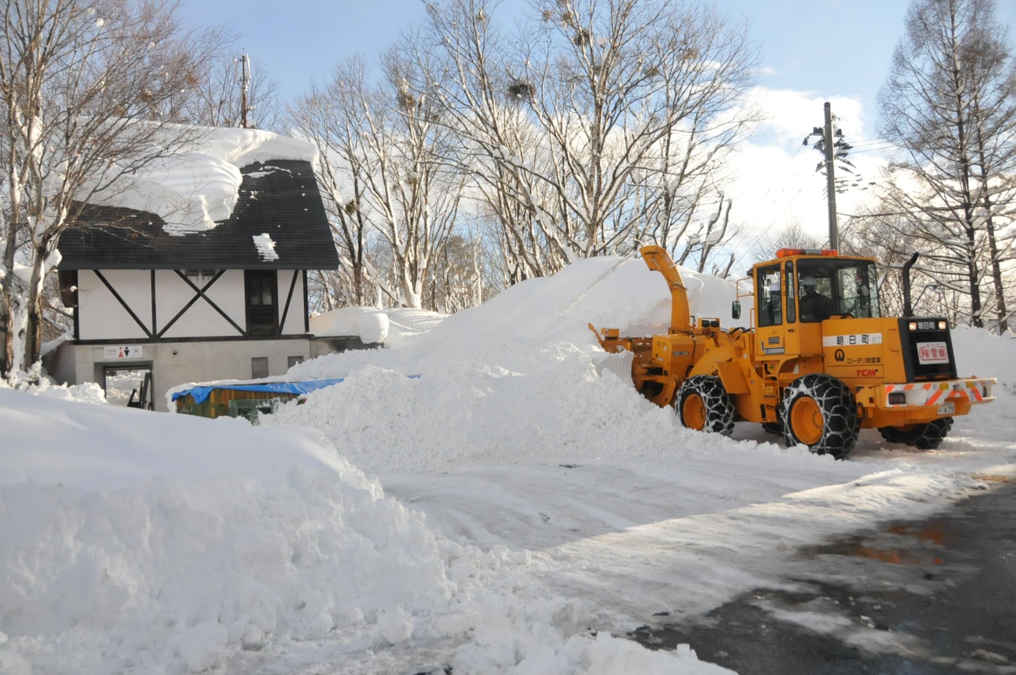 除雪車が雪を飛ばしほぼ完全にりんごを埋めている様子