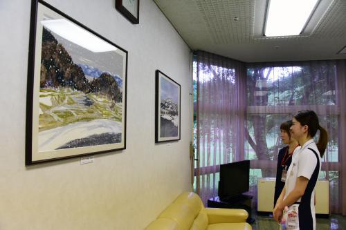 病棟 面会室に飾られたサック品を見ているスタッフの写真